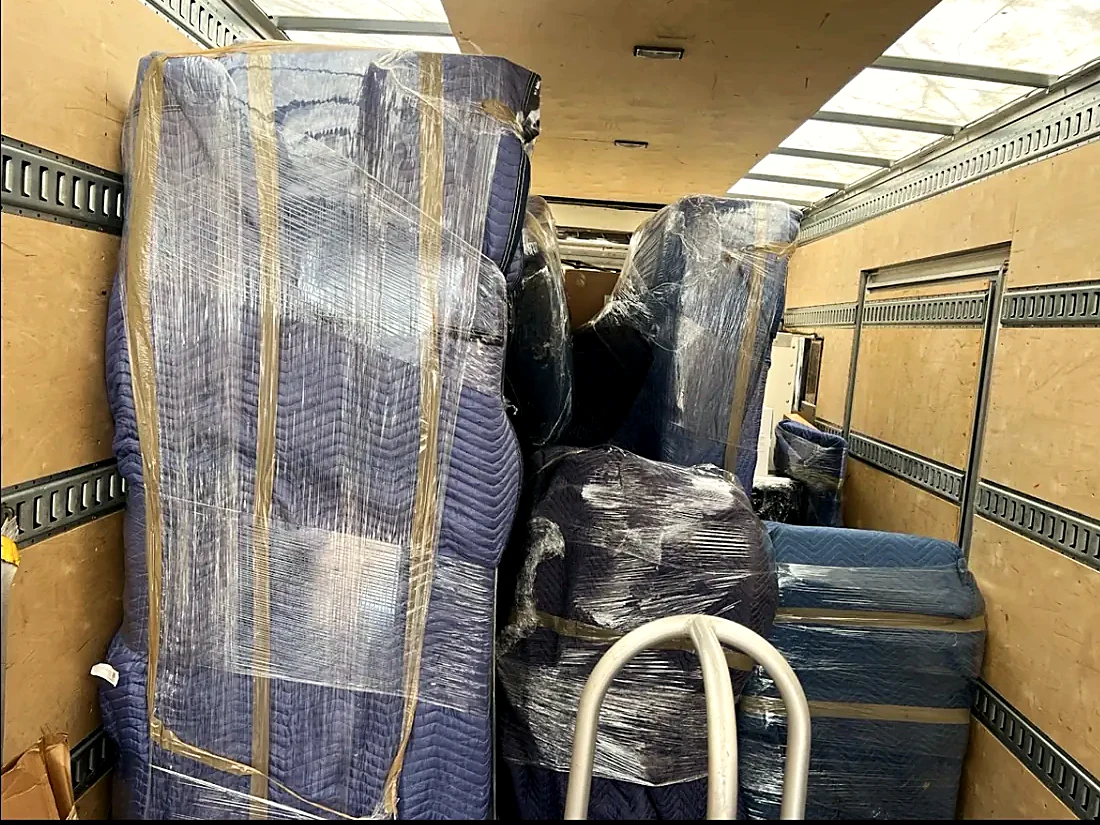 Furniture wrapped in moving blankets and strapped inside the truck on a Greenville move
